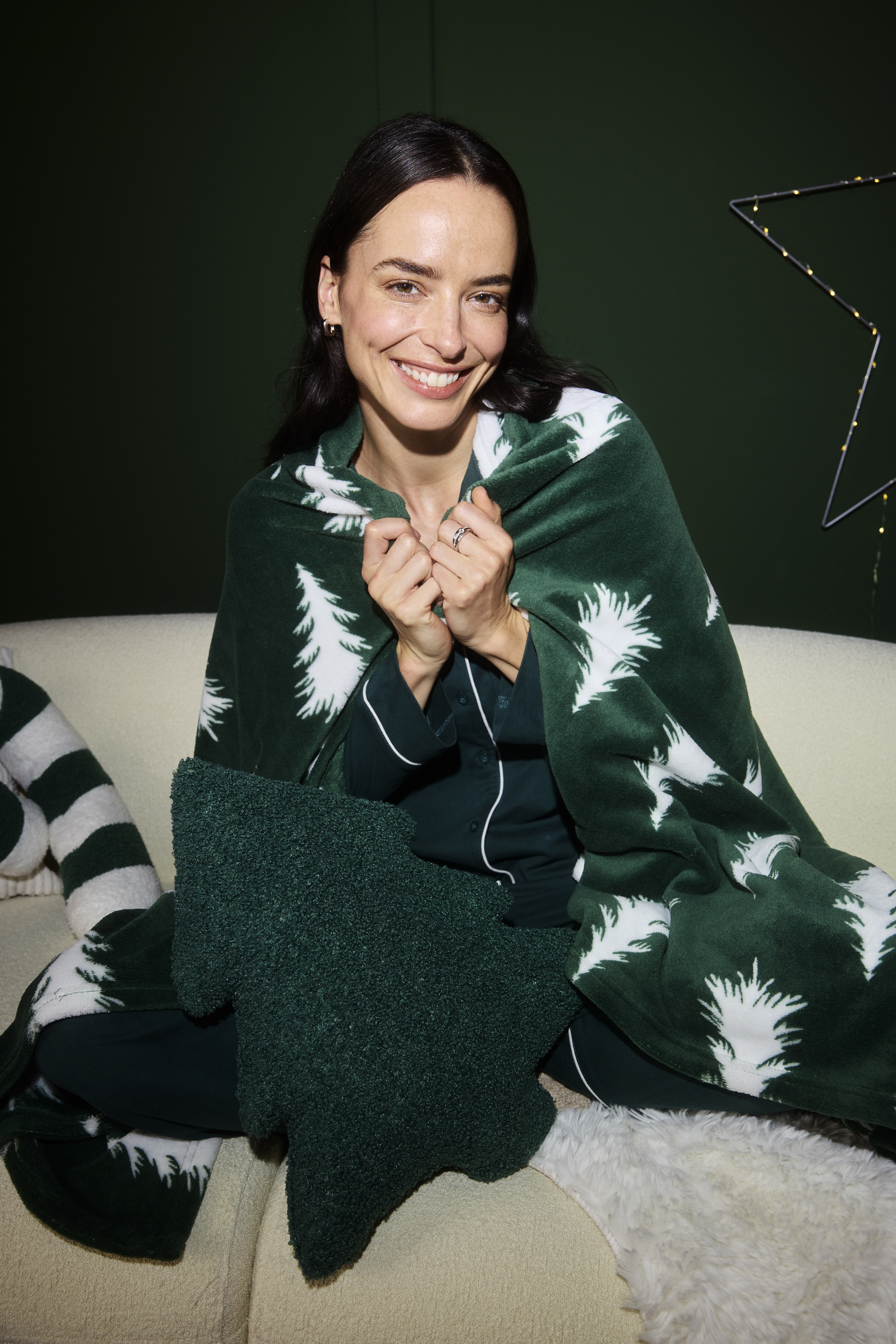 Grüner Pyjama und passende Decke mit Tannenbäumen.