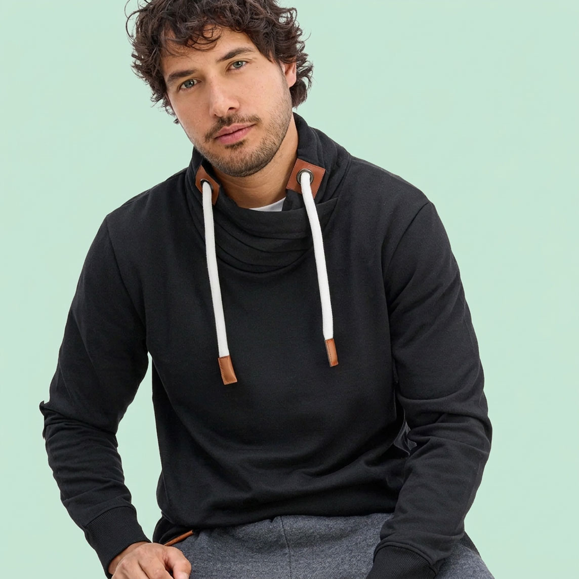 Schwarzer Hoodie mit stylischem Stehkragen und weißen Kordeln, kombiniert mit grauer Hose.