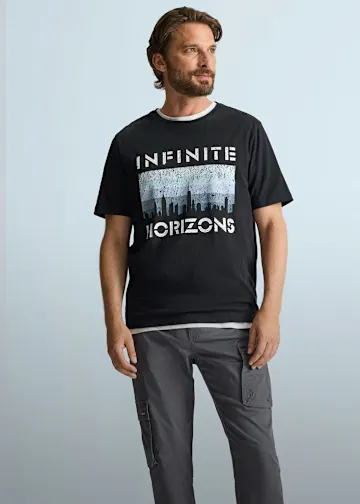 Schwarzes T-Shirt mit "Infinite Horizons" Aufdruck und lässiger grauer Cargohose.