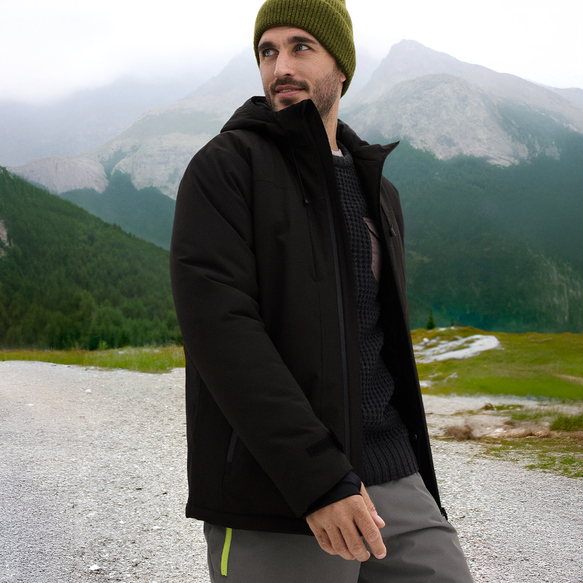 Schwarze Jacke und grüne Mütze für den perfekten Winterlook. 