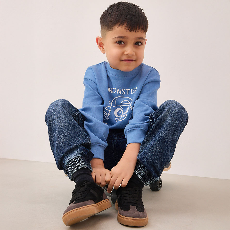 Ein kleiner Junge sitzt auf dem Boden.