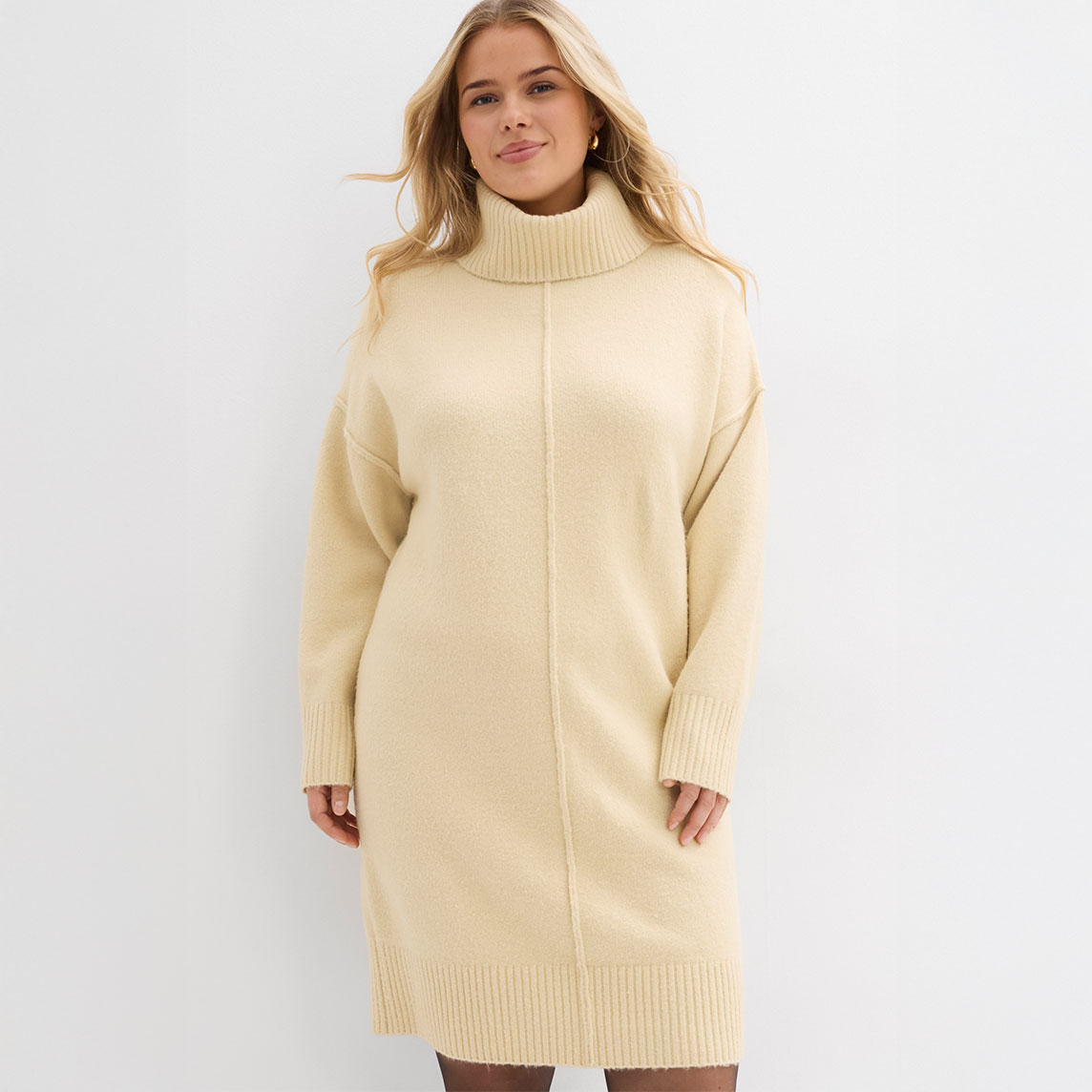 Cremefarbenes Strickkleid mit Rollkragen, übergroßer Passform und langen Ärmeln für kühle Tage.