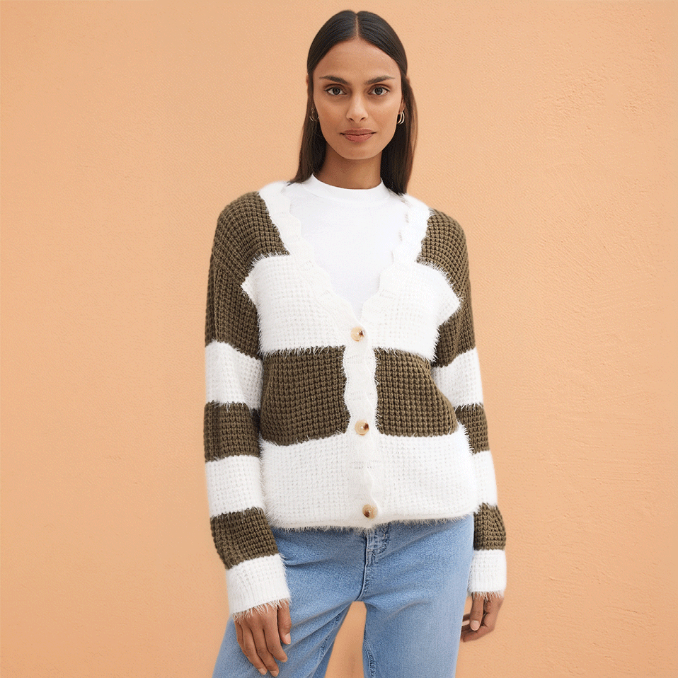 Gestrickter Cardigan in Weiß und Olivgrün, kombiniert mit hellblauer Jeans. 