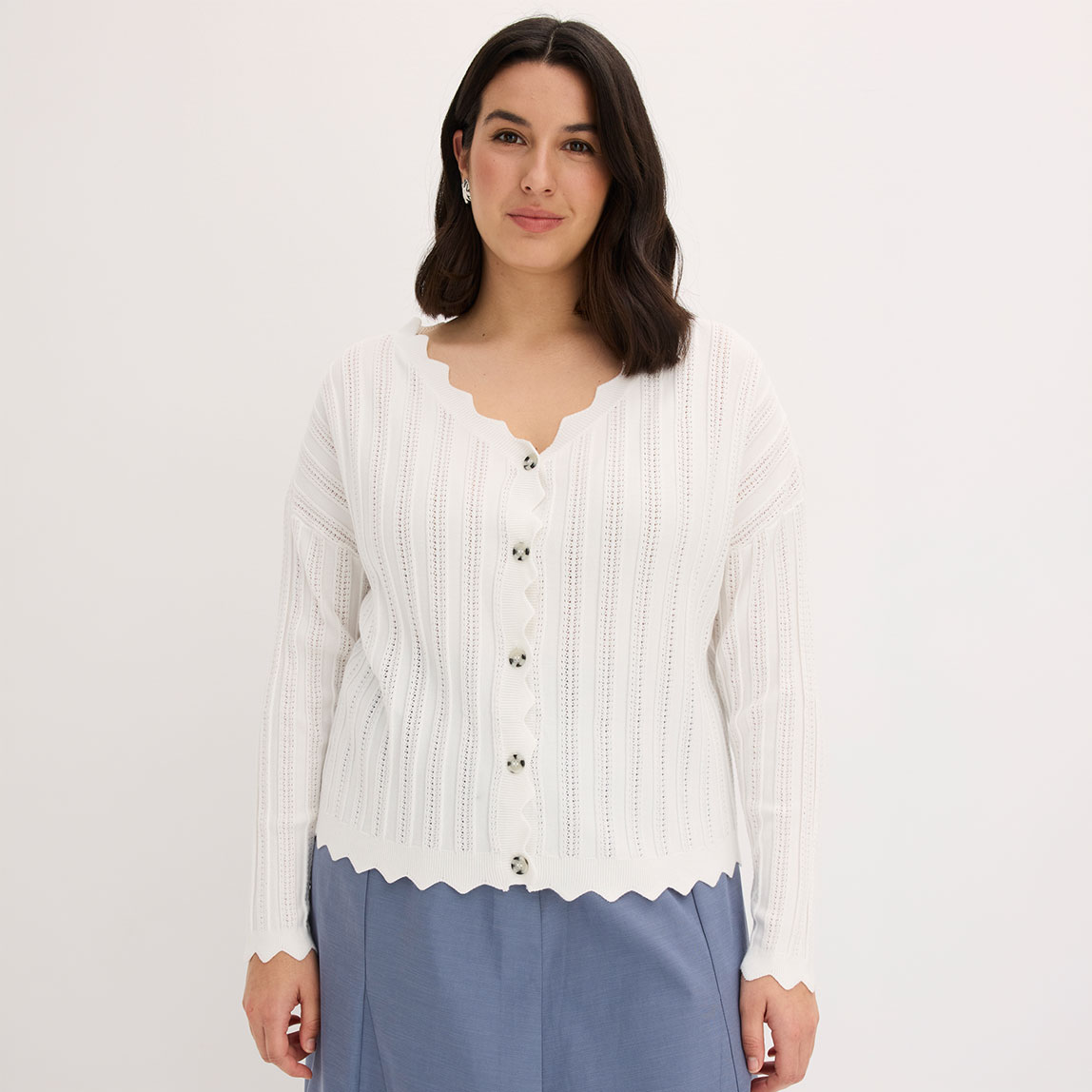 Weiße Lochmuster-Strickjacke mit Wellensaum.