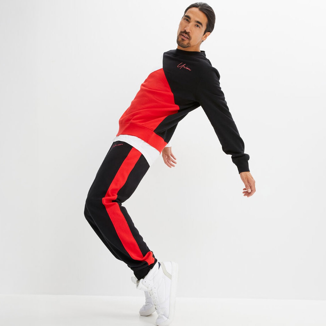 Sportlicher Trainingsanzug in Schwarz und Rot, kontrastreich gestaltet. 