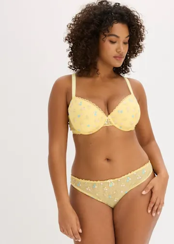 Frau trägt gelbe Unterwäsche mit Blumenstickerei 