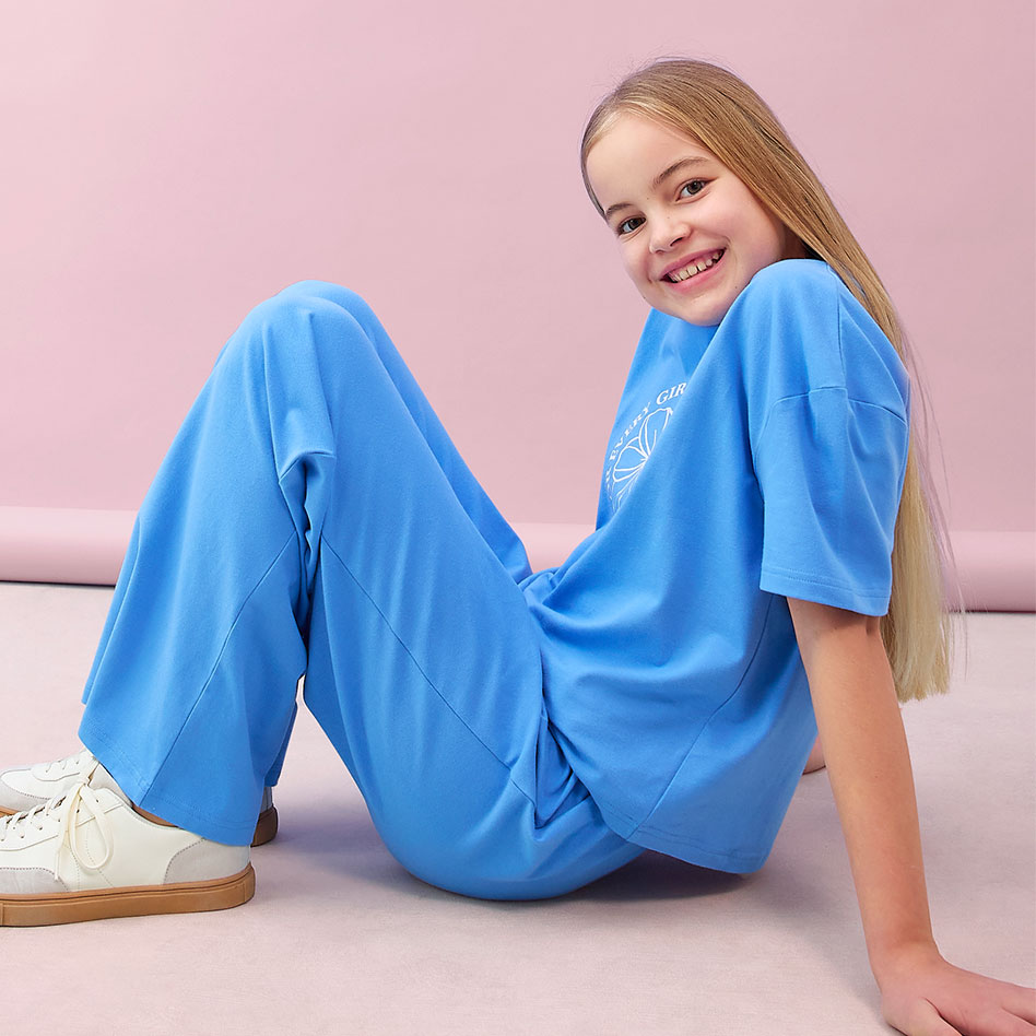 Helles, bequemes Blau dominiert das Outfit: Weites T-Shirt und lockere Hose für entspannten Komfort.