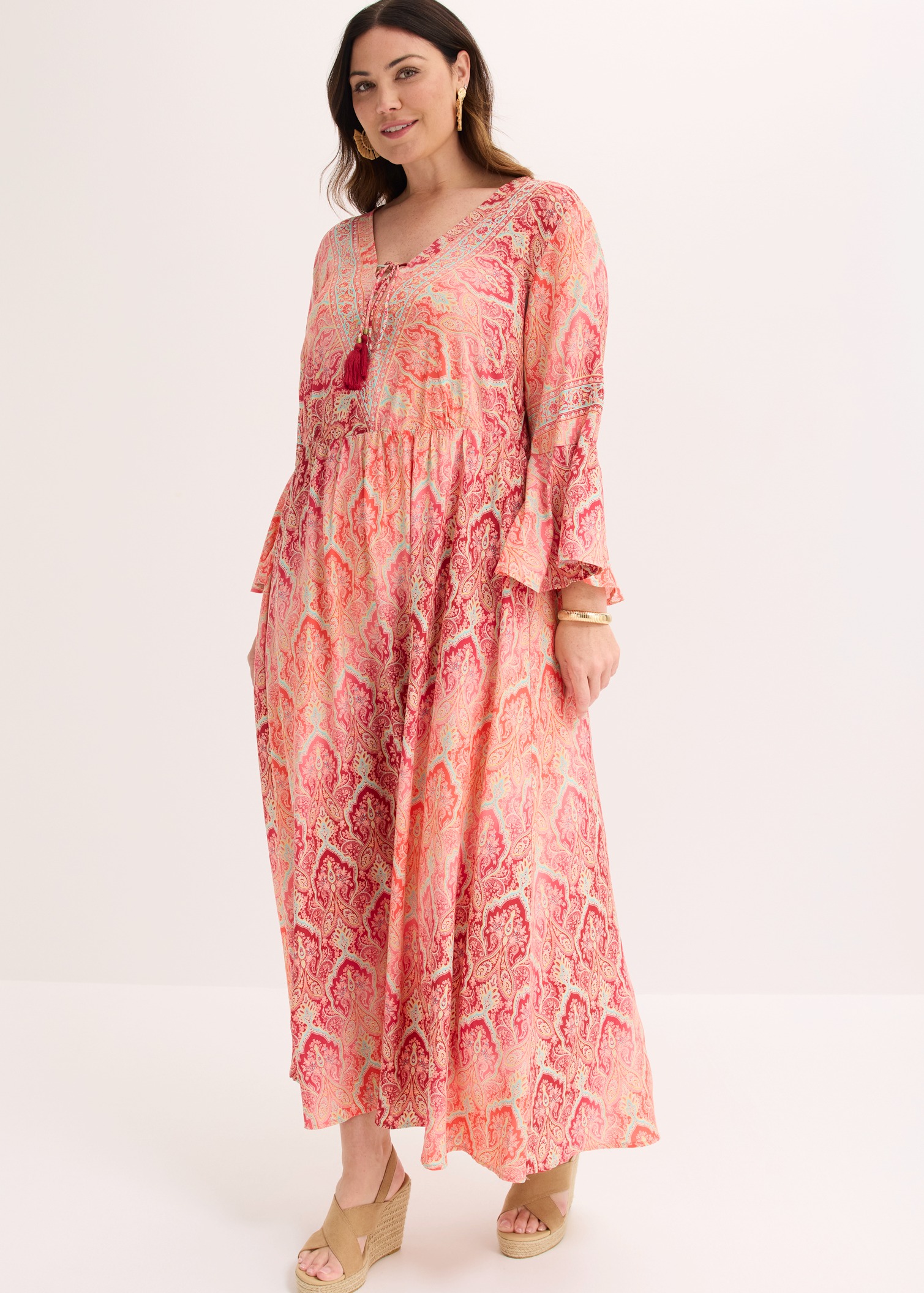 Rosa Maxikleid mit Paisley-Muster und Keilsandalen.