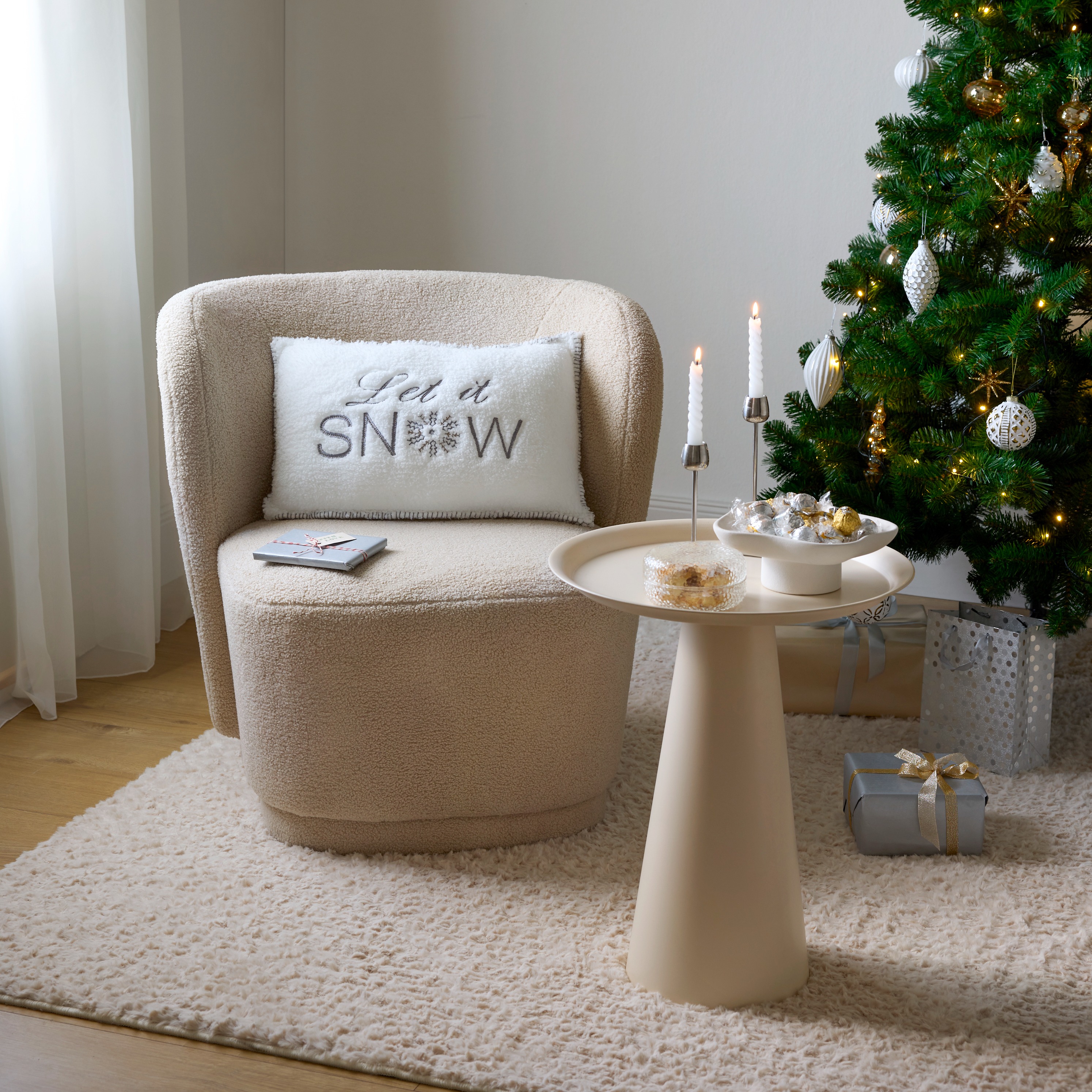 Gemütlicher Sessel mit flauschigem Bezug und winterlichem Kissen.