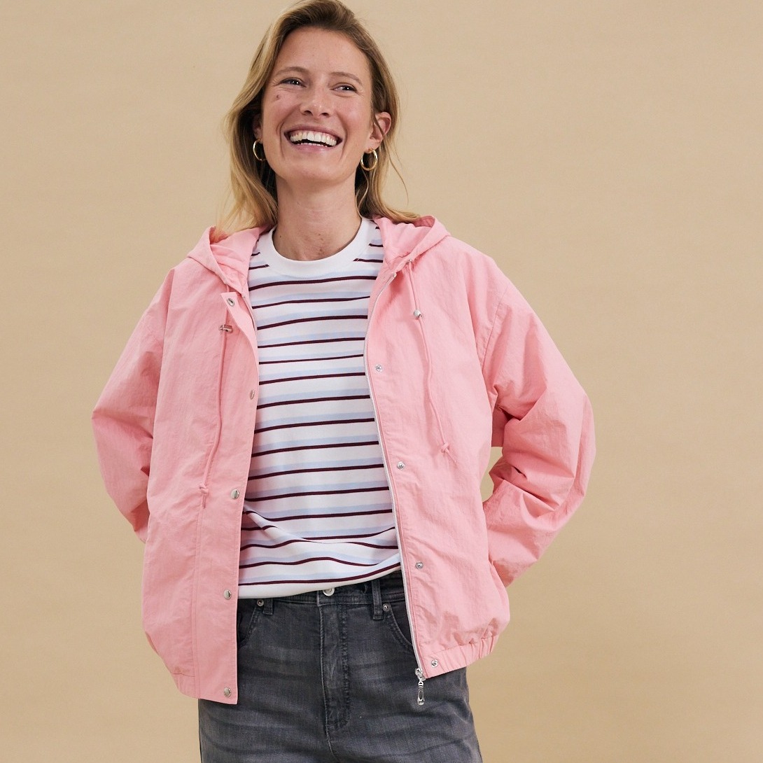 Rosa Jacke über gestreiftem Shirt, kombiniert mit grauer Jeans - lässiger Freizeitlook.