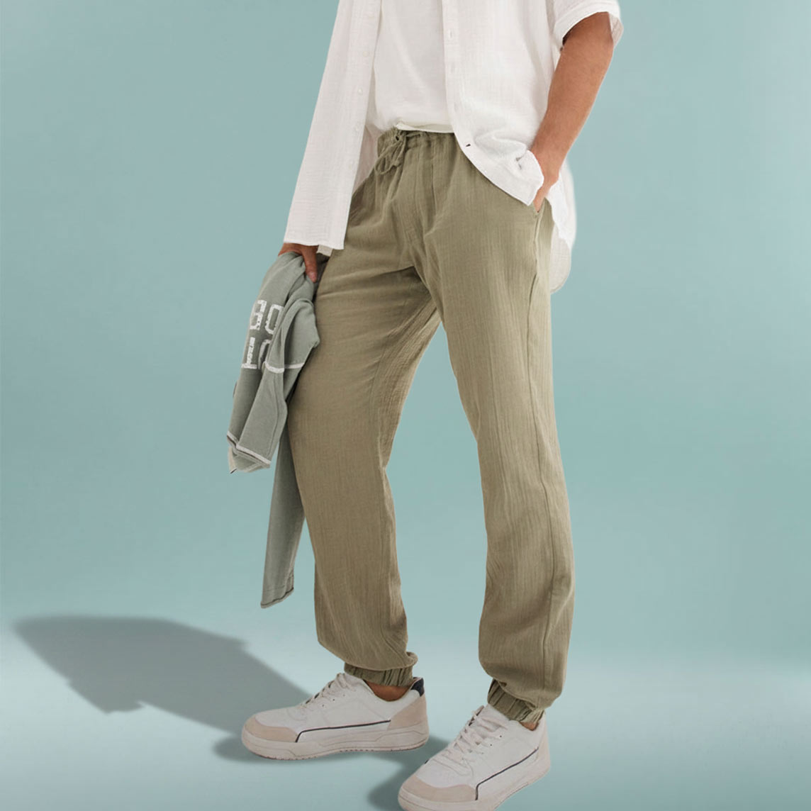 Entspannte olivgrüne Hose mit weißem Oberteil und hellem Sweatshirt.