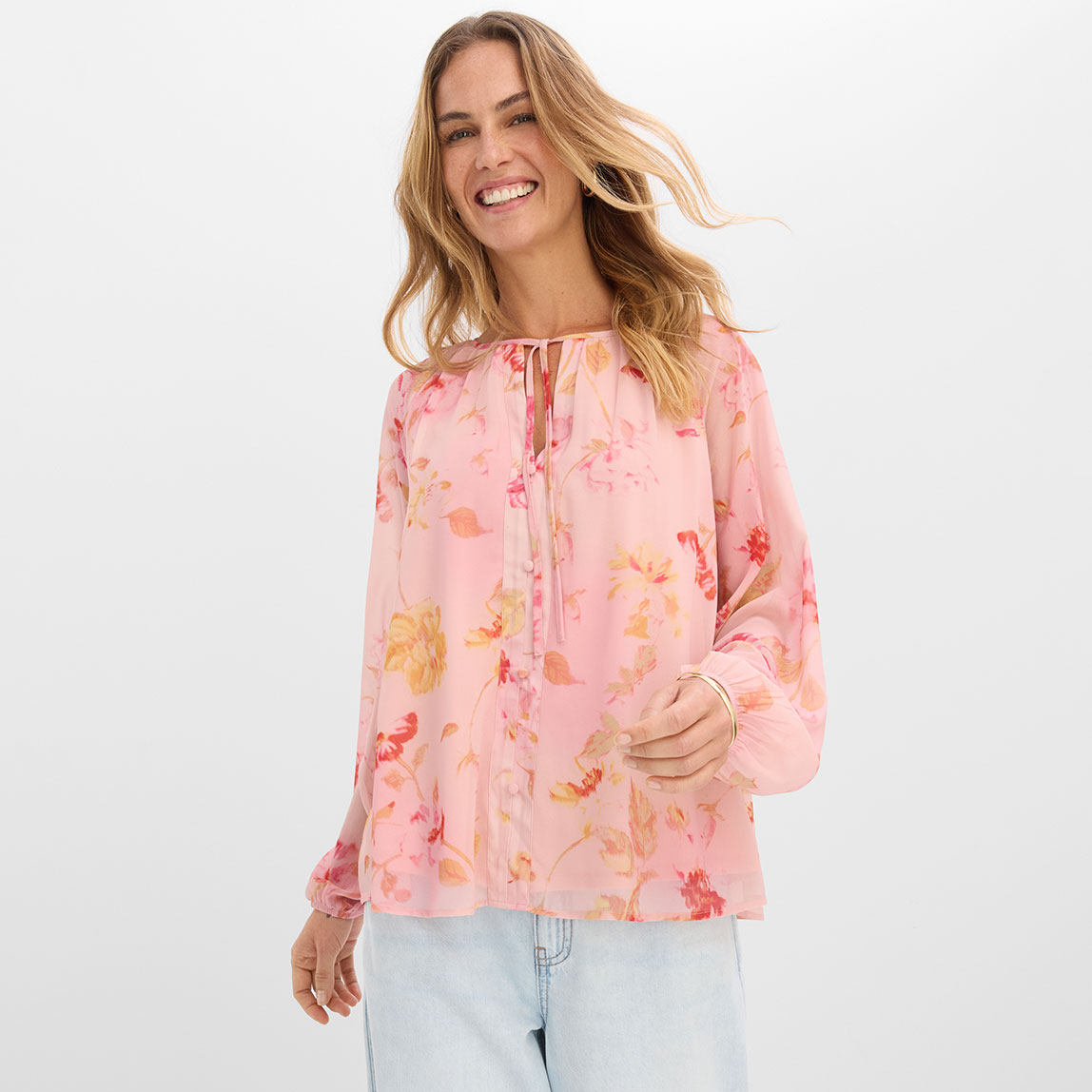 Rosa Bluse mit Blumenmuster und helle Jeans.
