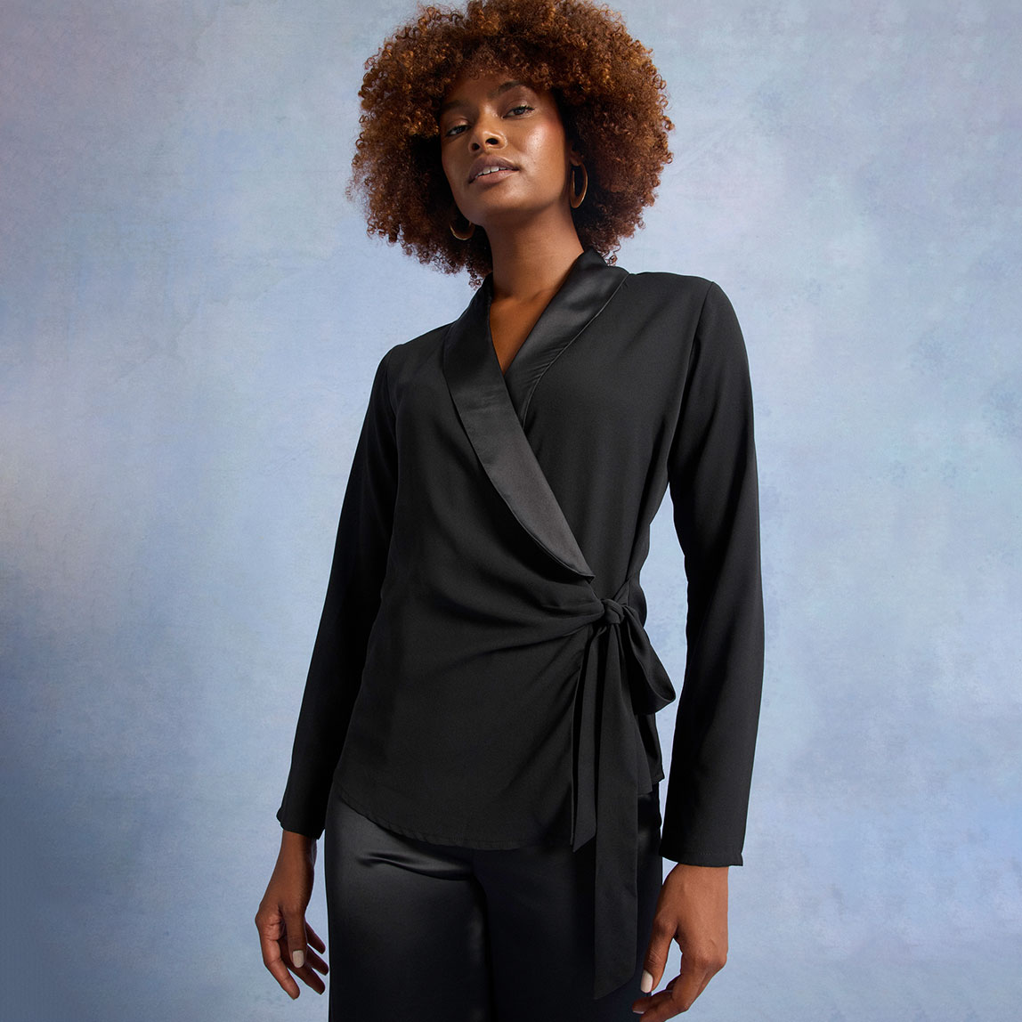 Schwarze Wickelbluse mit Revers und langen Ärmeln. 