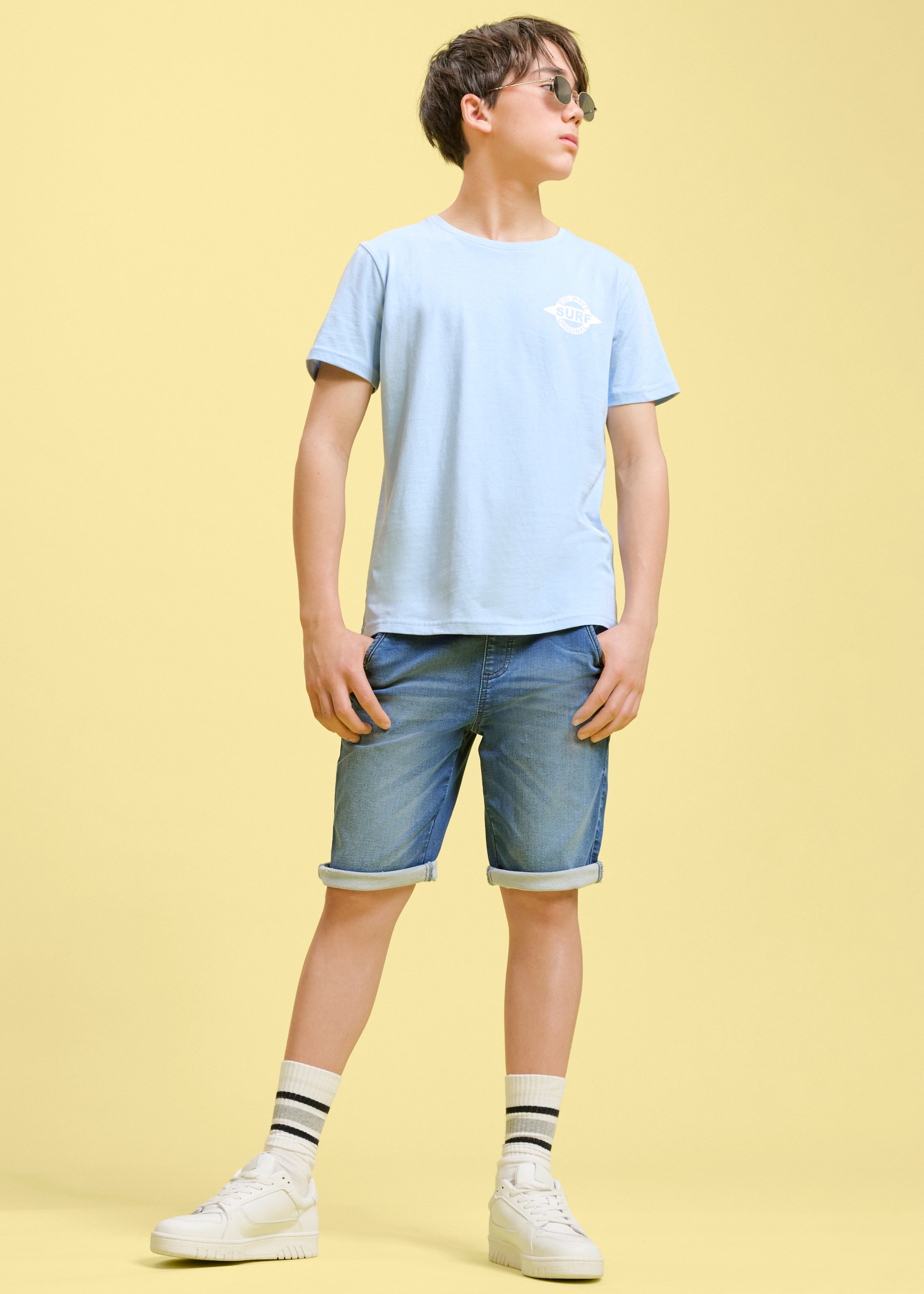 Hellblaues T-Shirt und Denim-Shorts.