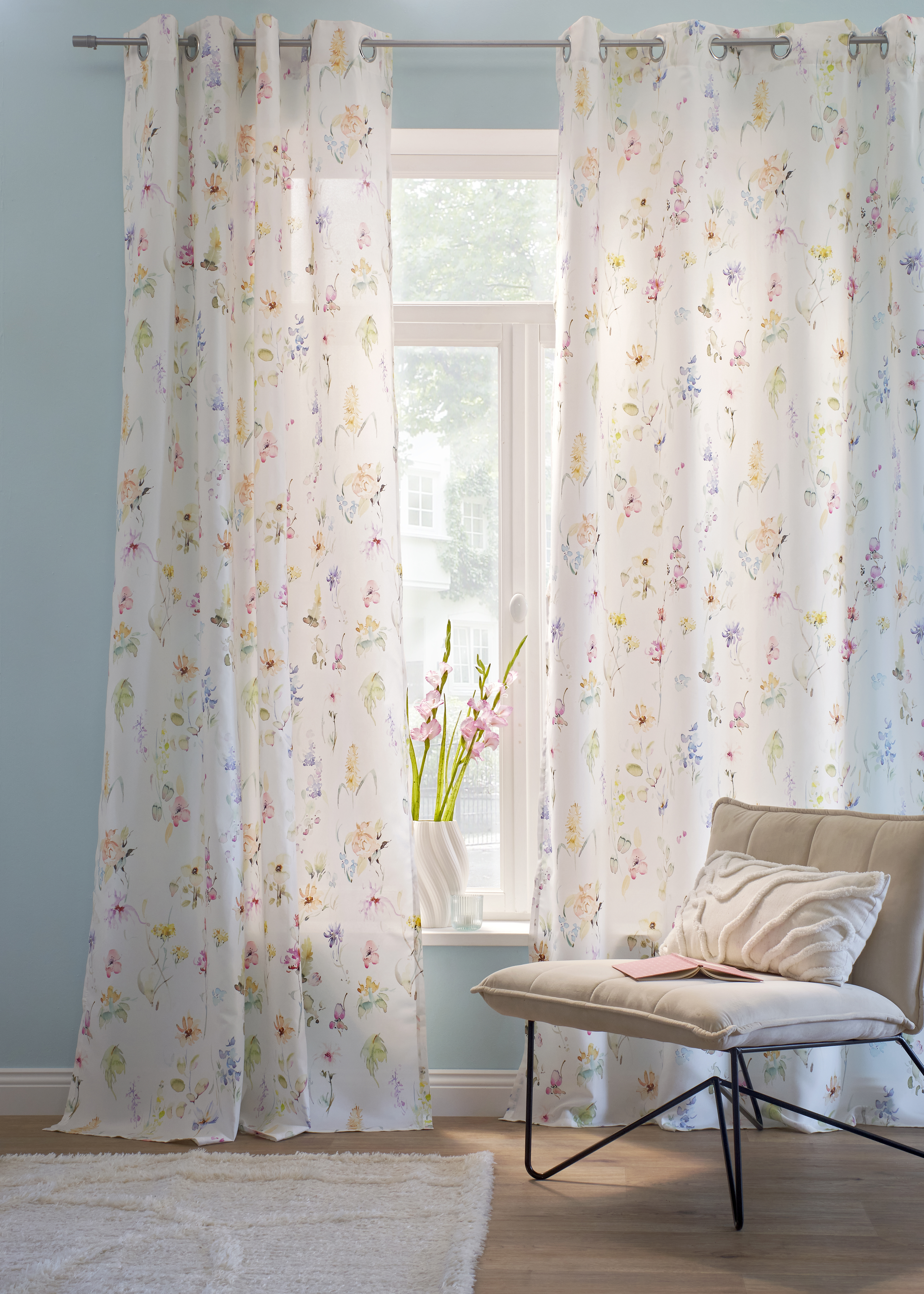 Im Bild ist keine Kleidung, sondern florale Vorhänge und ein Sessel zu sehen.