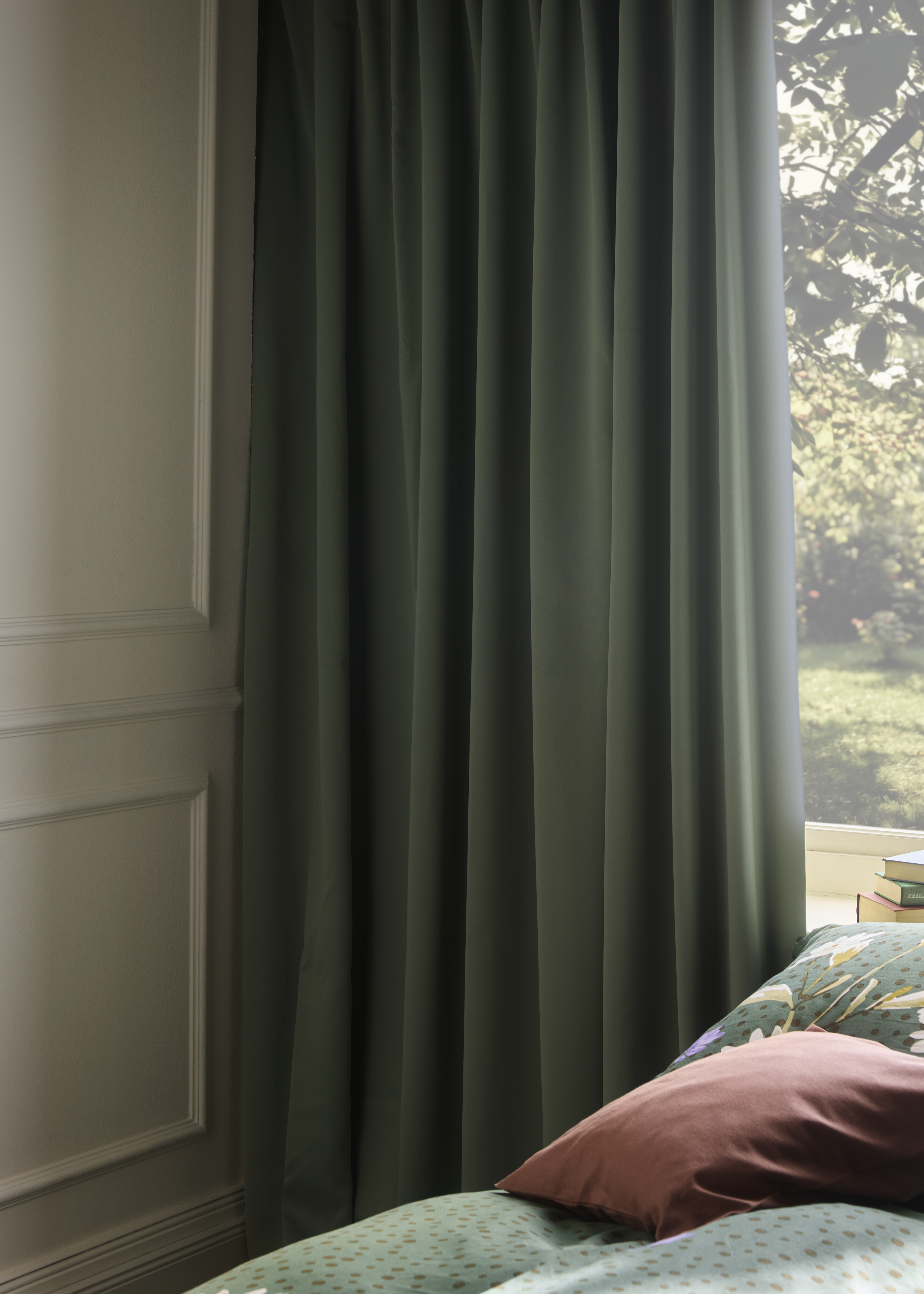 Grüne Vorhänge schmücken das Fenster.