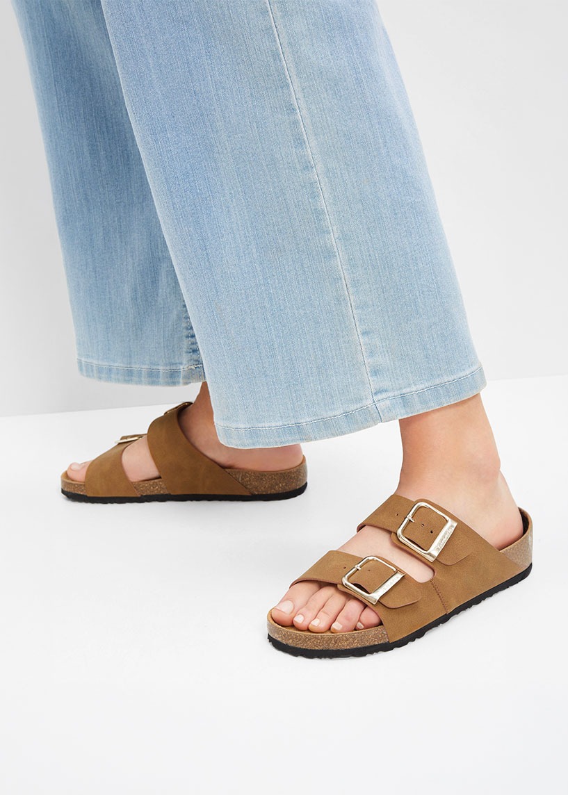 Helle Jeans kombiniert mit braunen Sandalen schaffen einen sommerlichen Look.