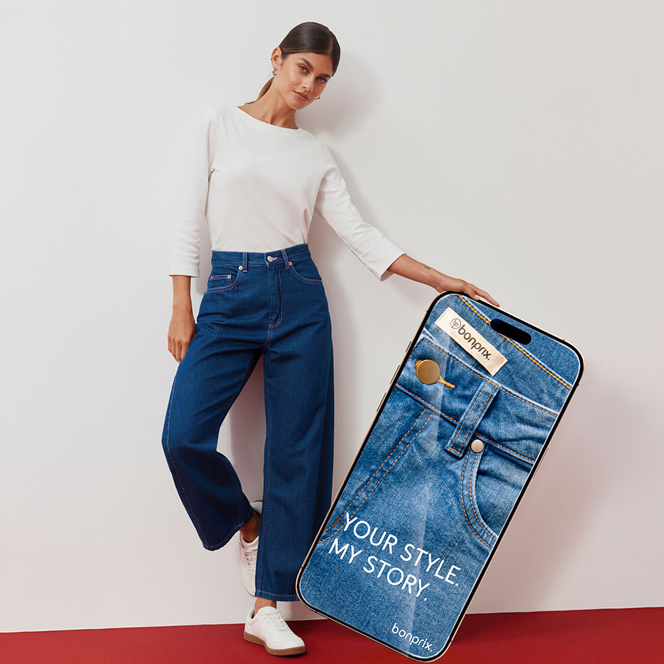 Weißes Oberteil, modische weite Jeans und Sneaker.