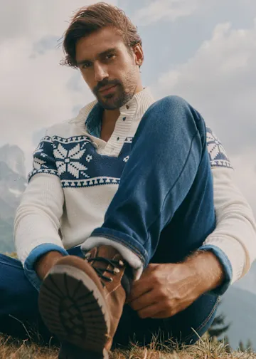Warmer Norwegerpullover, Jeans und braune Stiefel.