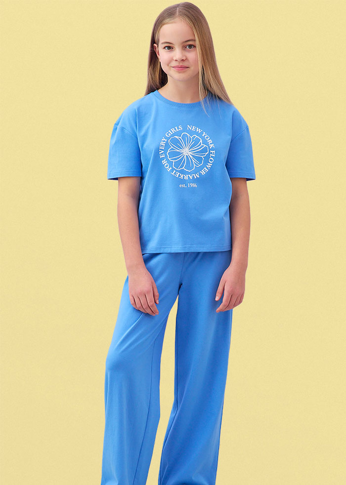 Ein hellblaues T-Shirt mit Aufdruck und passende weite blaue Hose.