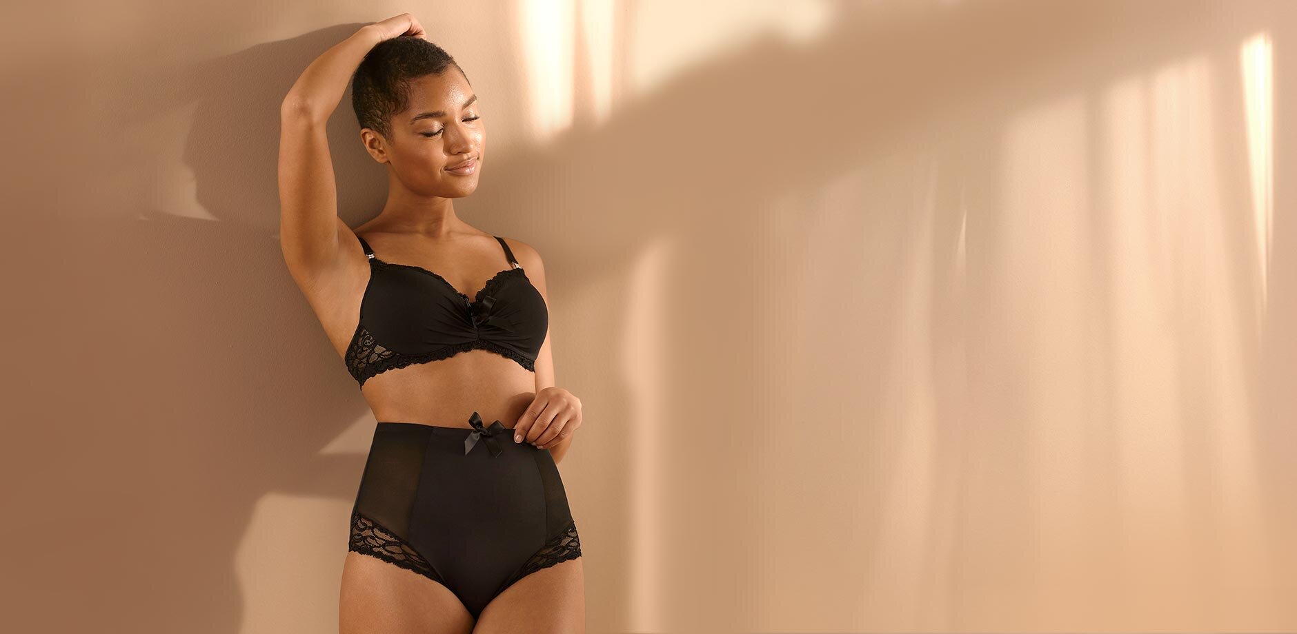 Elegante schwarze Spitzenwäsche betont feminine Silhouette. Hochgeschnittene Höschen und passender BH strahlen Selbstbewusstsein aus.