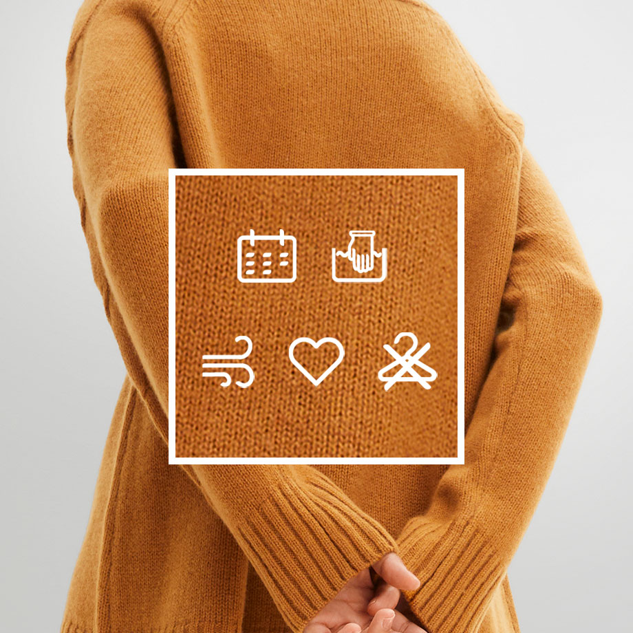 Ein warmer, senfgelber Pullover mit Symbolen für Kalender, Geschenk, Wind, Herz und Werkzeug.