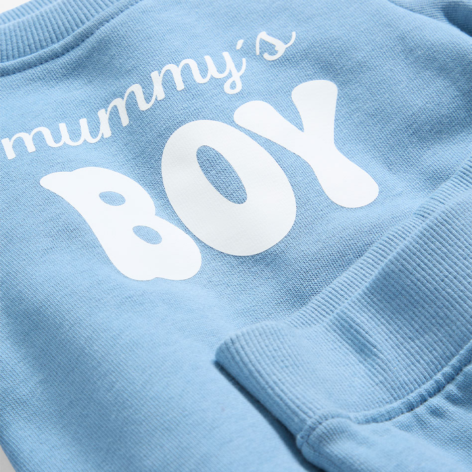 Babykleidung in Pastellfarben: Blaues Set für Jungen und rosafarbenes Set für Mädchen.