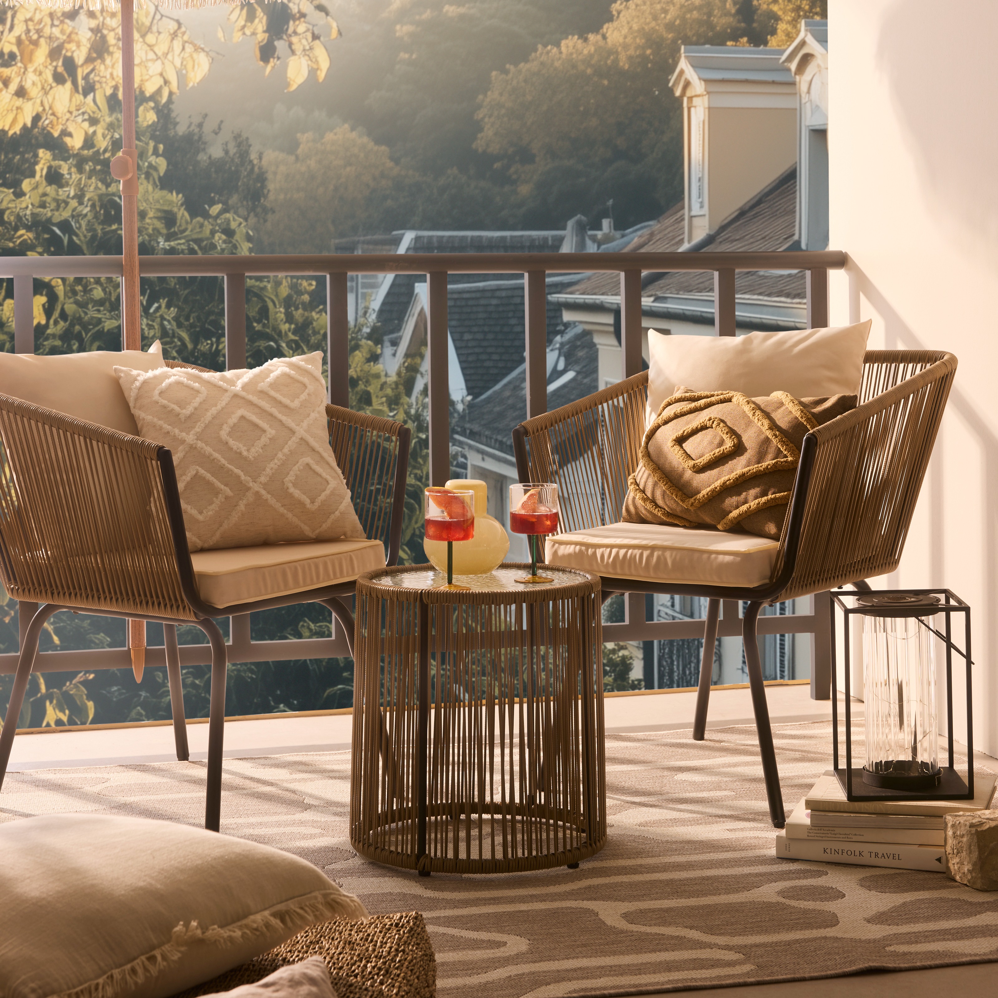 Gemütliche Rattansessel mit flauschigen Kissen laden zum Entspannen auf der sonnigen Terrasse ein.