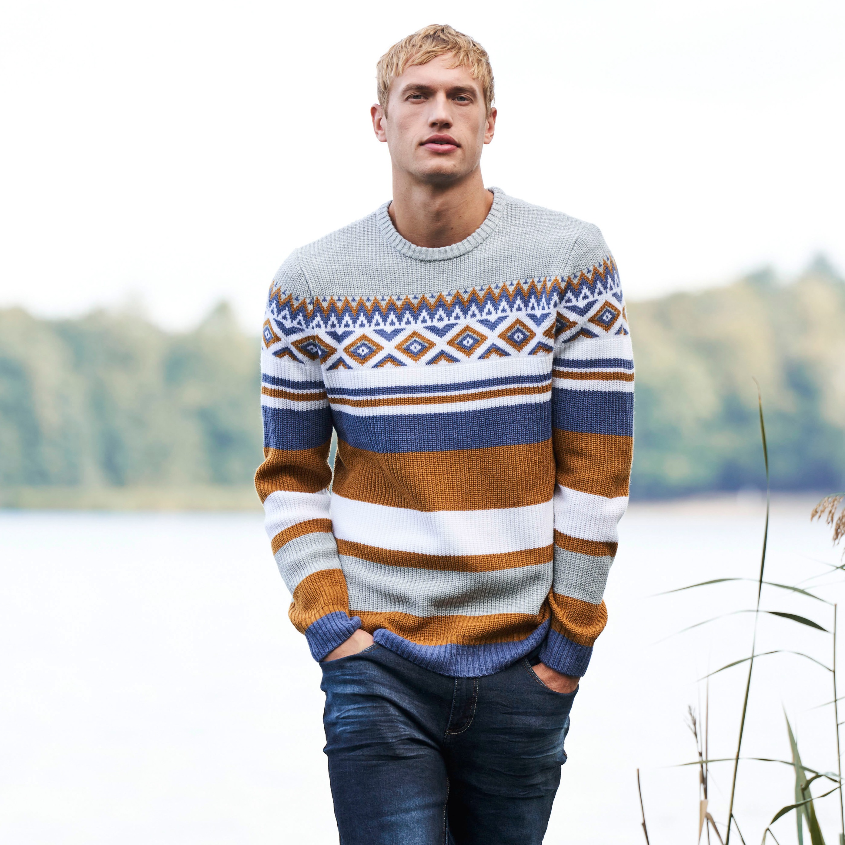 Gemusterter Strickpullover in Erdtönen mit blauem Akzent.