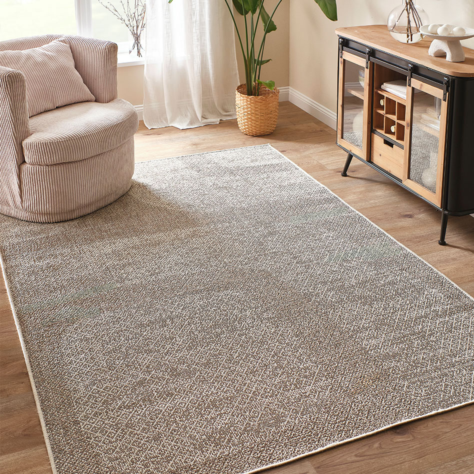 Weicher Teppich und luftige Gardinen schaffen eine einladende Wohnatmosphäre.