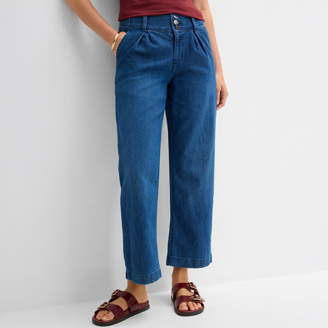 Modische weite Jeans mit Bundfalten, rotes Shirt und passende weinrote Sandalen.