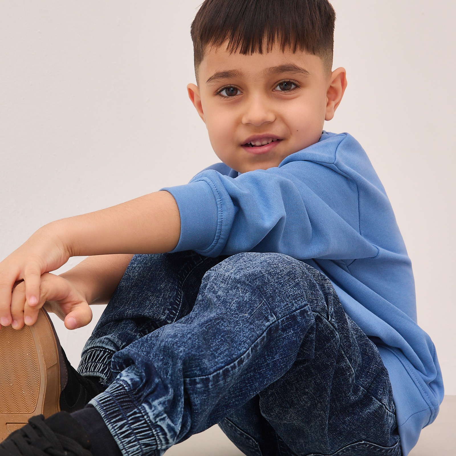 Blauer Pullover und gemusterte Jeans bilden einen lässigen Look für junge Mode.