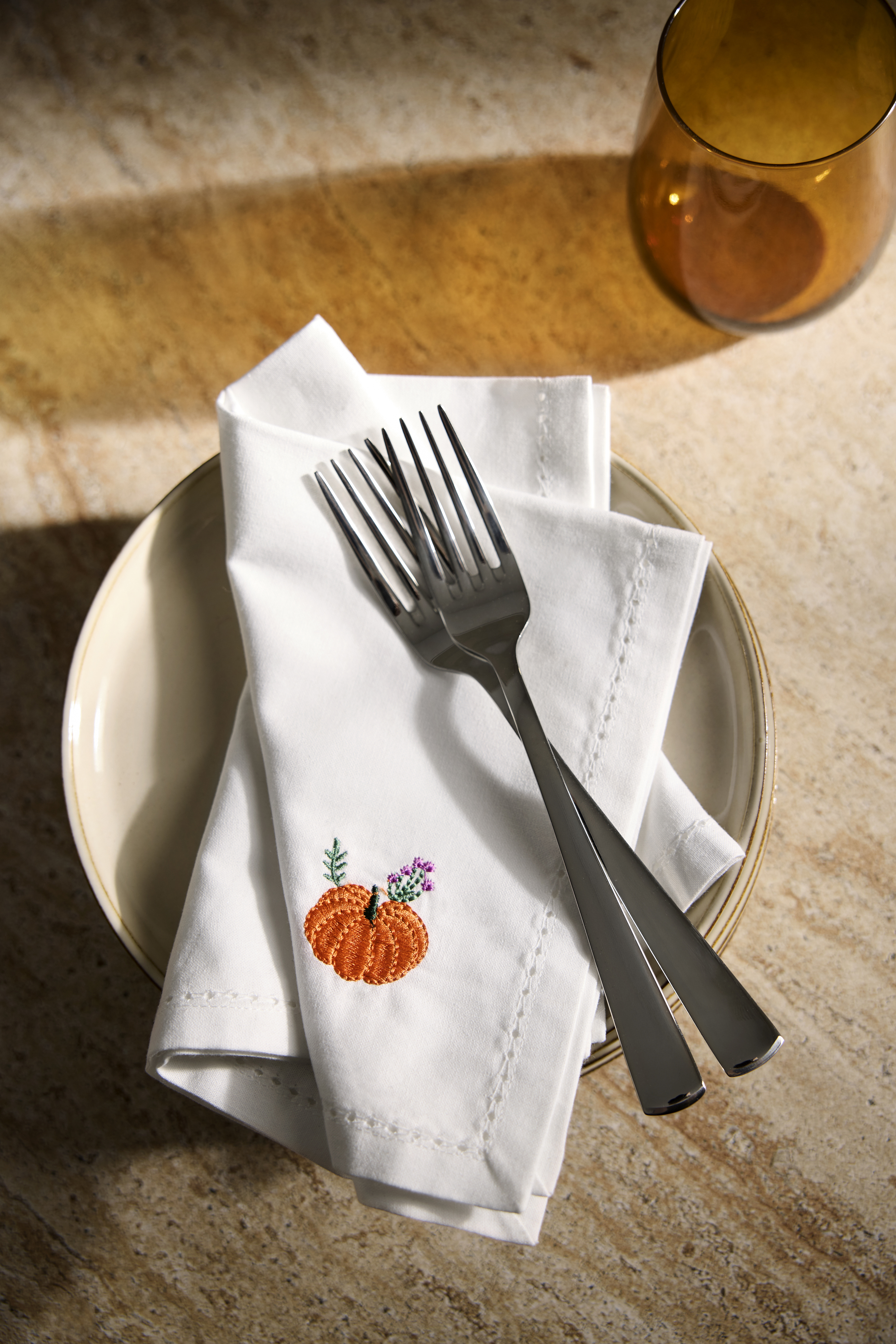 Weiße Stoffserviette mit Kürbis-Stickerei.