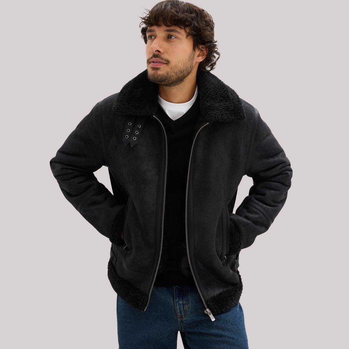 Lederimitat-Jacke und blaue Jeans.