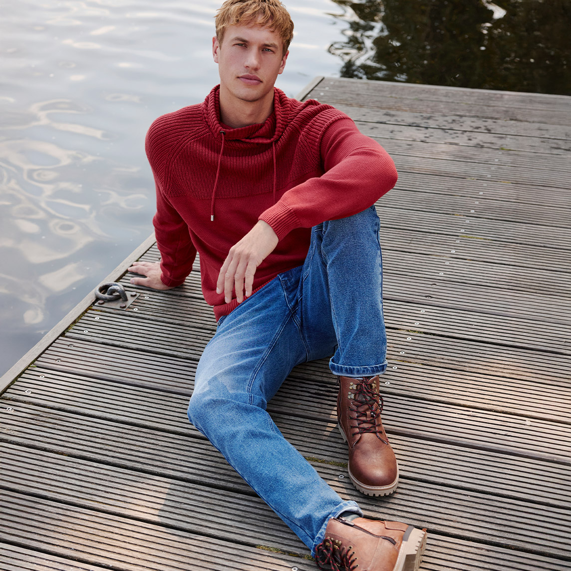 Roter Kapuzenpullover trifft auf blaue Jeans und braune Lederstiefel.