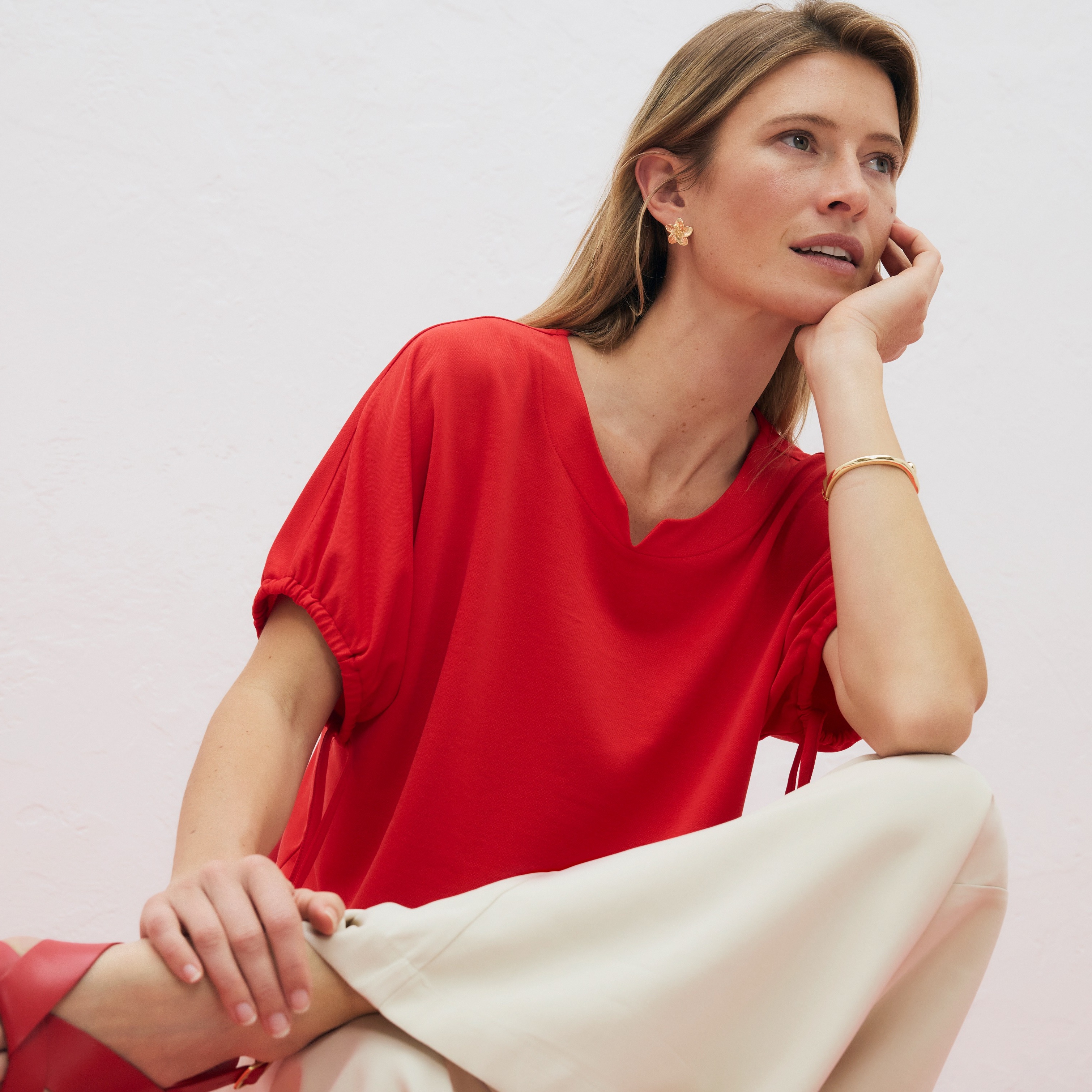Rotes Oberteil mit V-Ausschnitt und kurzen Ärmeln.