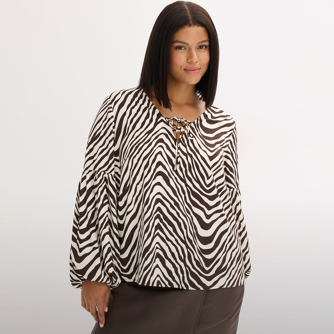 Bluse mit Zebramuster und dunklem Rock.