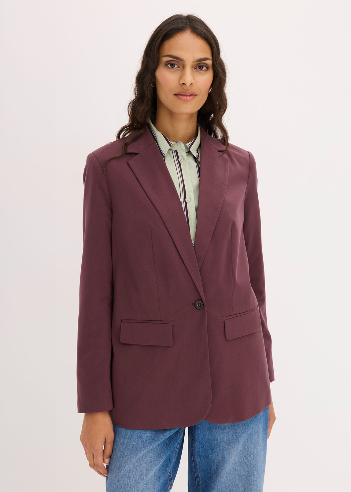 Modischer bordeauxfarbener Blazer, hellgrünes Streifenhemd und lässige Jeans.