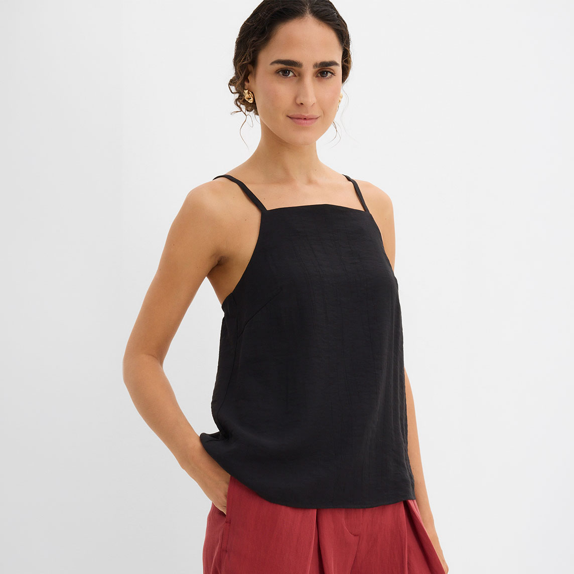 Schwarzes Top kombiniert mit einer roten weiten Hose für einen lässigen Look.