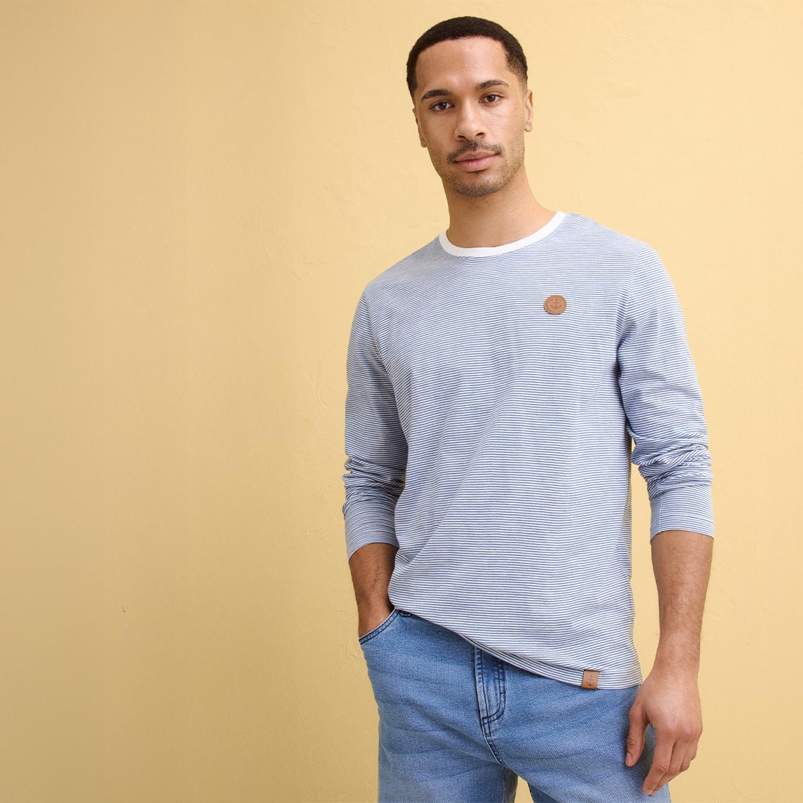 Hellblaues Langarmshirt und Jeans. 