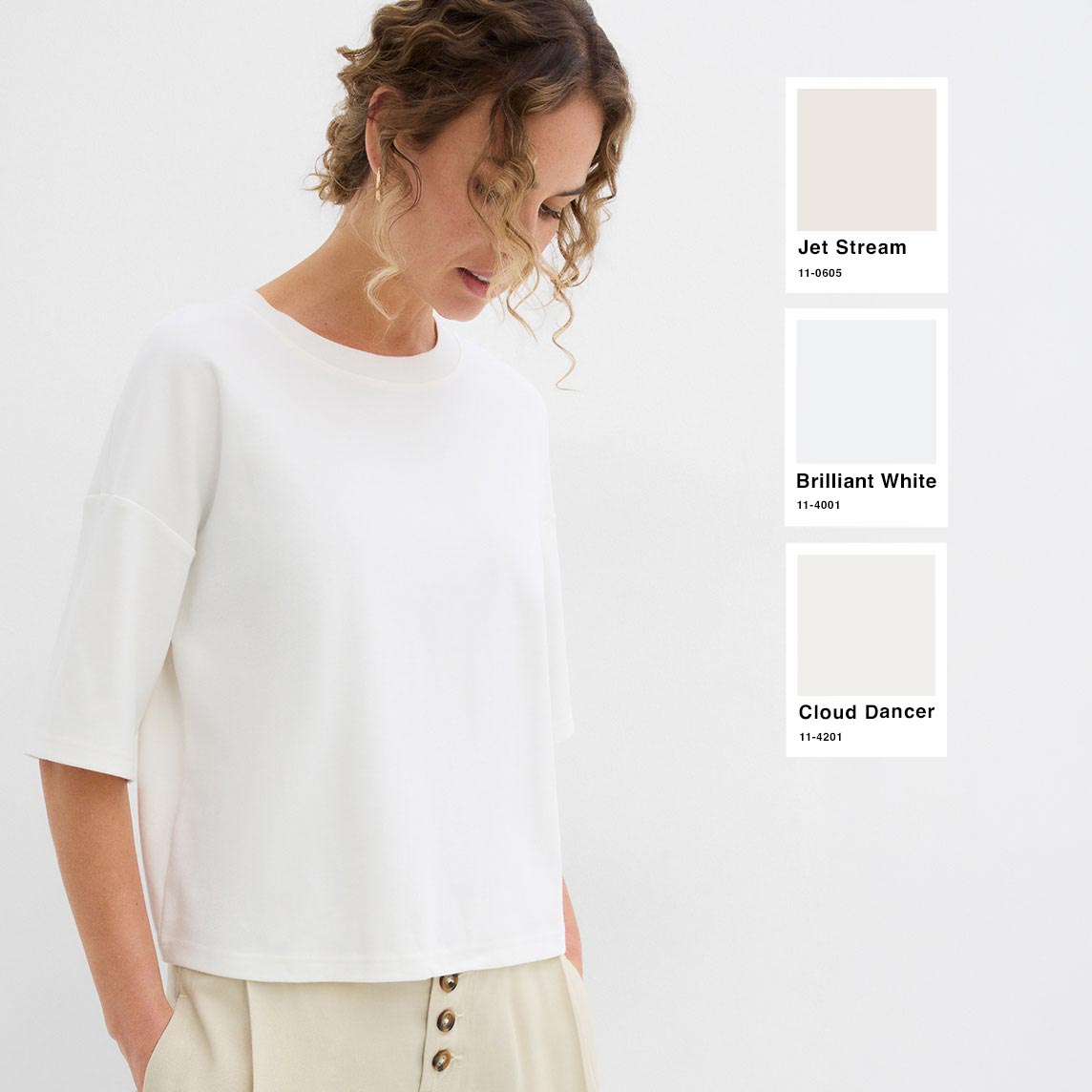Modisches, lockeres weißes Shirt kombiniert mit heller Hose in Crèmetönen.