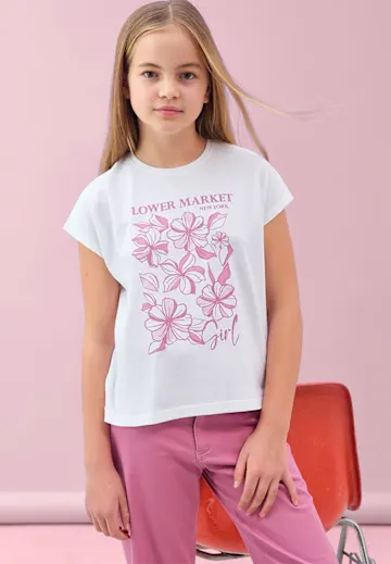 Weißes T-Shirt mit rosa Blumenmuster und pinke Hose.