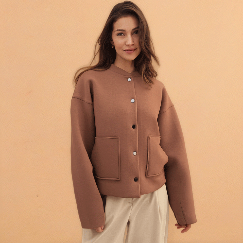 Eine braune Jacke mit Knöpfen und Taschen, kombiniert mit einer cremefarbenen Hose.