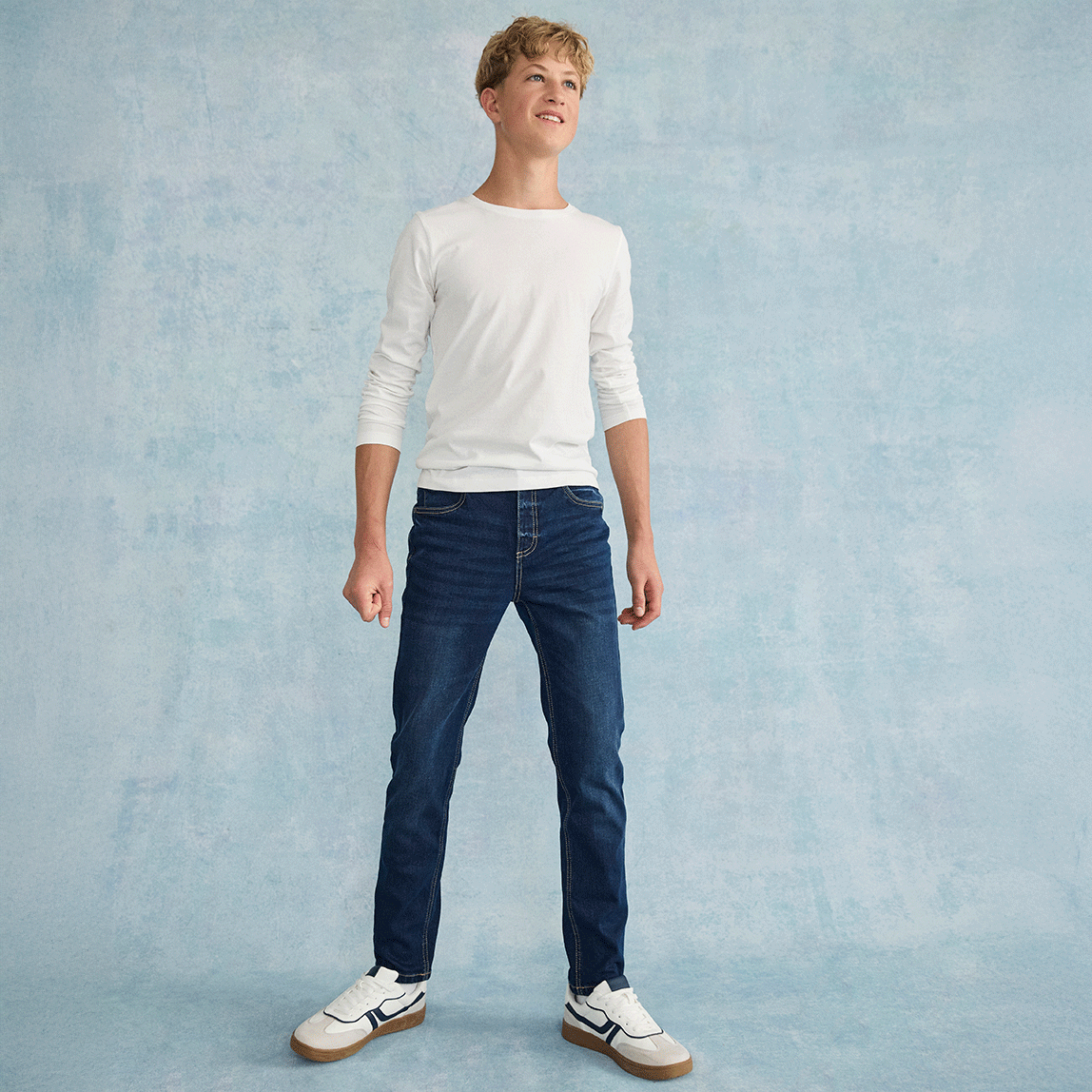 Lässiger Look mit weißem Langarmshirt, klassischer Jeans und weißen Sneakern.