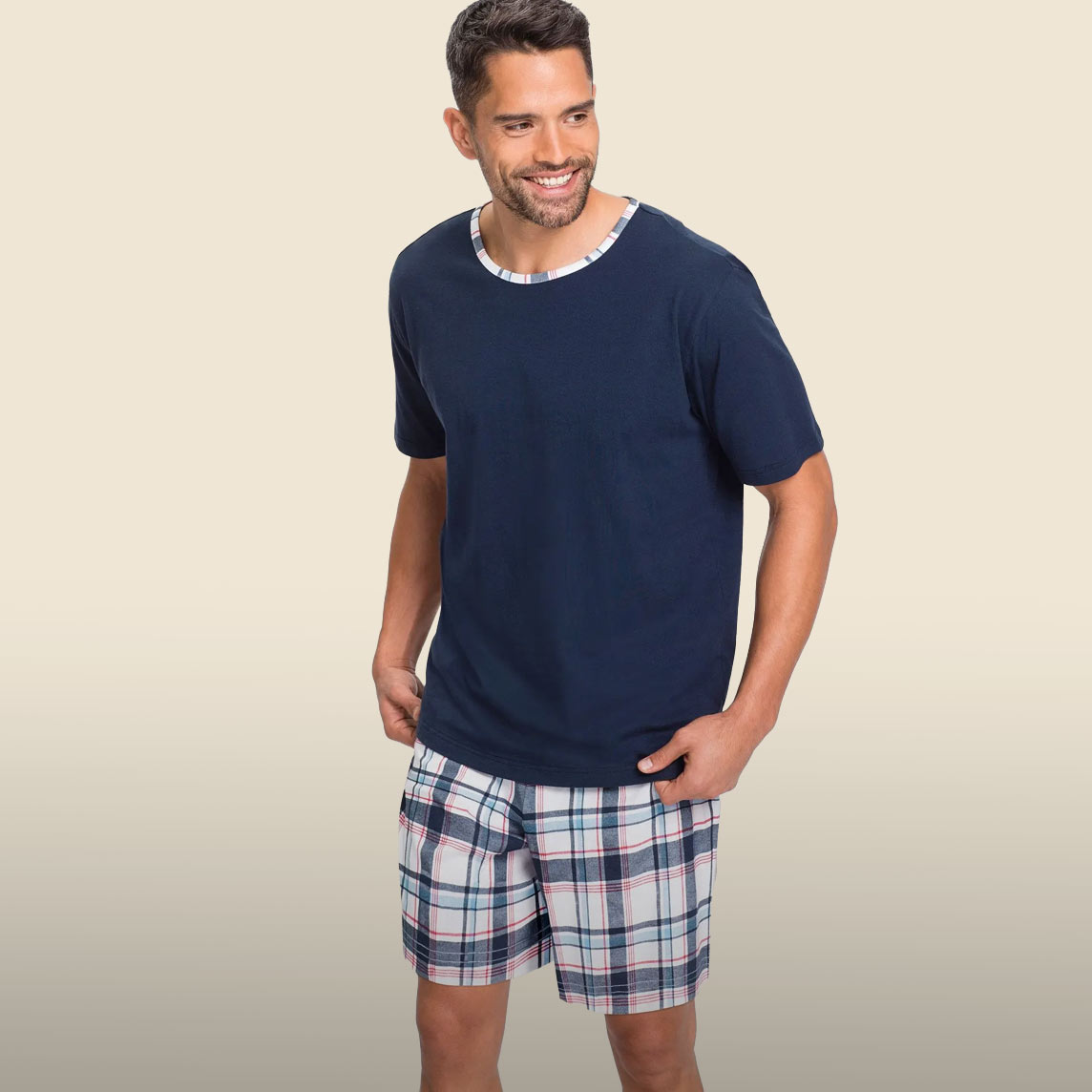 Kurzer Schlafanzug mit marineblauem Shirt mit Musterkragen und dazu passende karierte Shorts.