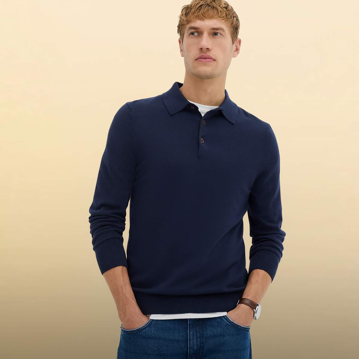 Eleganter dunkelblauer Pullover mit Kragen. Klassische blaue Jeans.