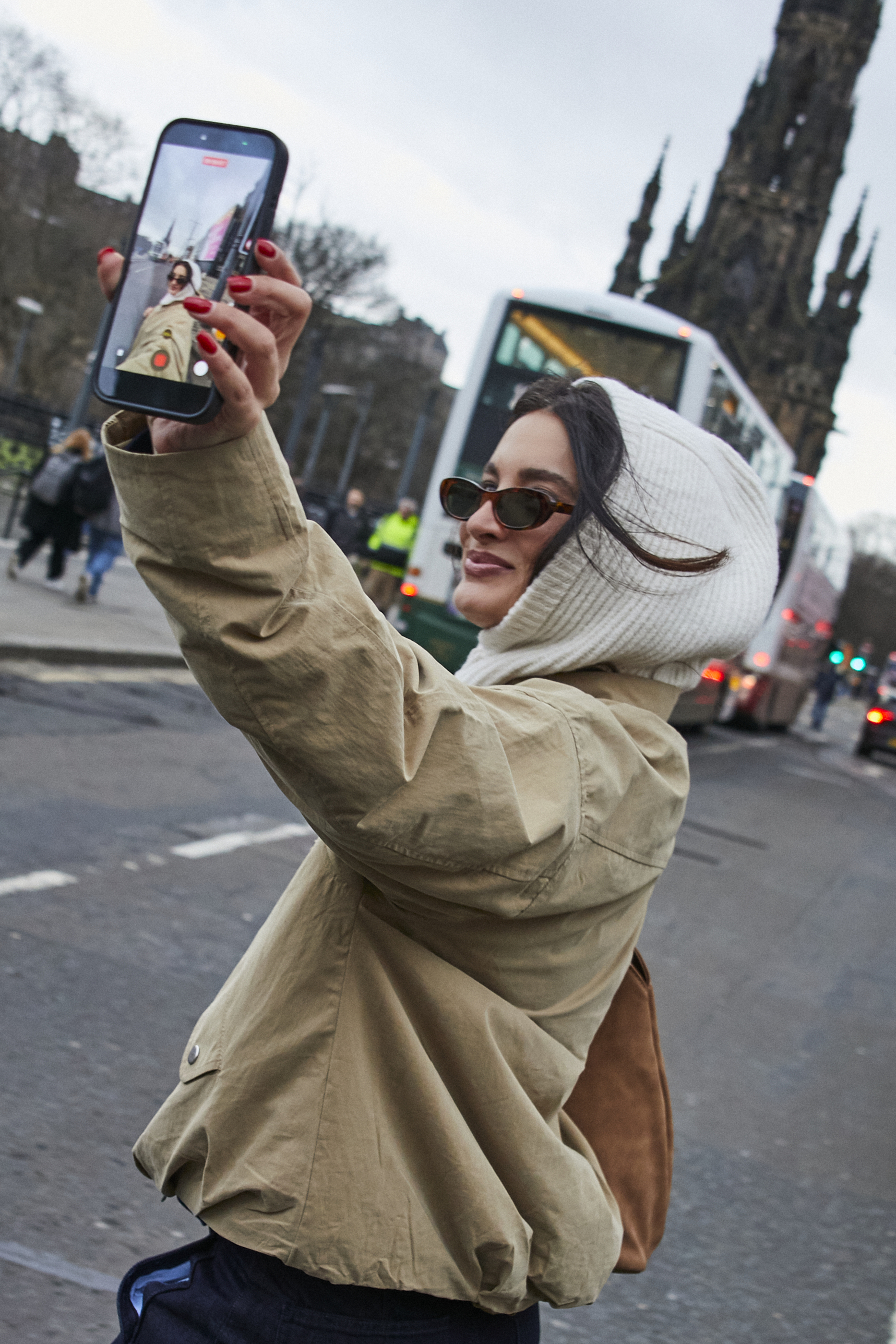 Beiger Mantel und weiße Strickmütze.
