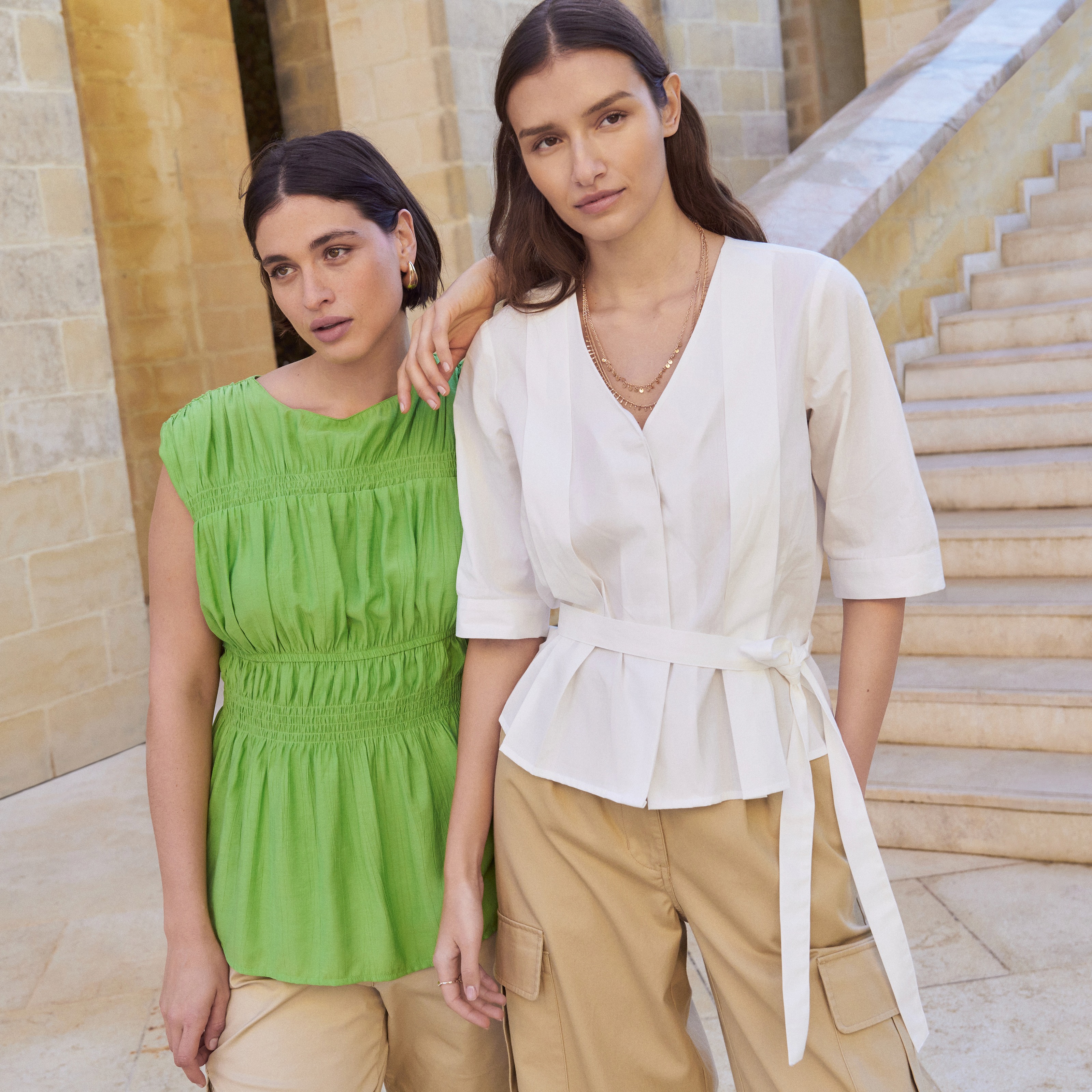 Frische Sommermode: Grünes Kleid, weiße Bluse und beige Hose für einen eleganten Look.