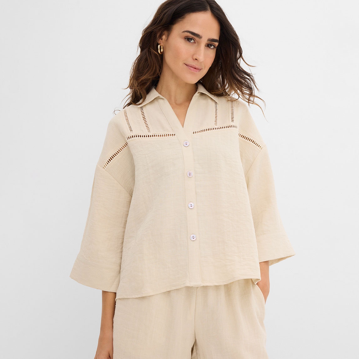 Elegante beige Bluse mit dekorativen Nähten und passender Hose im lässigen Set.