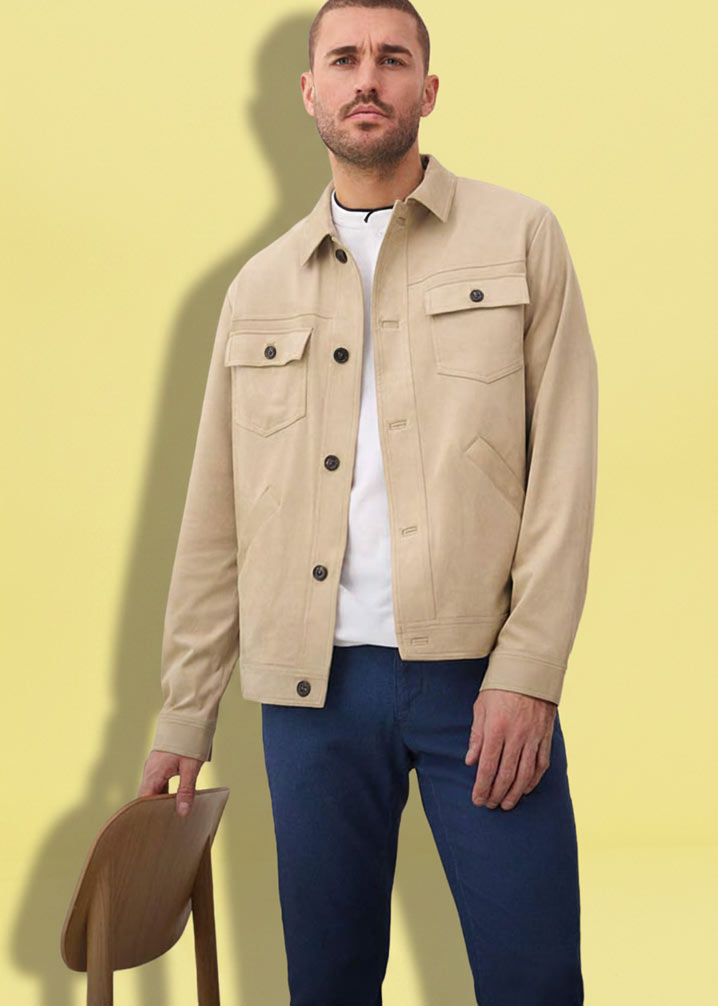 Mann trägt beige Hemdjacke über weißem T-Shirt und dunkelblaue Hose.